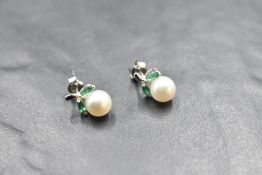 A pair of 14ct white gold stud earrings having cultured pearl and emerald style decoartion, approx