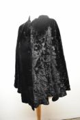 An Art Deco black velvet cape, cut so it drapes beautifully to the reverse, fully lined in satin,