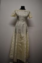 A mid to late 1950s wedding dress, having short sleeves and Peter Pan collar with braided edge.
