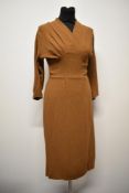 A 1940s coffee coloured crepe day dress, having cross over pleated bodice and kick pleats to back.