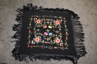 An early 20th century fringed shawl, having vibrant embroidery.