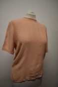 A 1940s blouse in a pale salmon shade, having buttons fastening to reverse and pin tucks to front.
