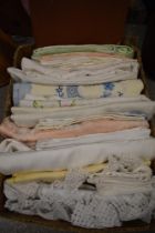A collection of vintage and antique linen, including damask tablecloths.