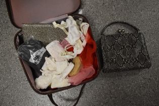 A vanity case containing a selection of vintage accessories, including head scarves.