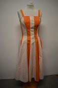A 1950s Blanes cotton sun dress, having panels of orange interspersed with white panels with