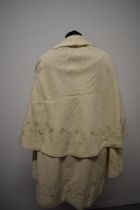 A 1920s cream childs cape, having hand worked silk embroidery.