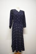 A 1940s navy blue wool day dress, having white embroidered dots throughout, having 3/4 length