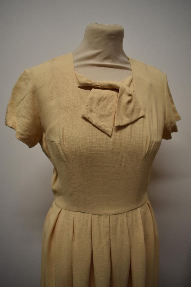 A 1950s buttermilk textured cotton day dress with tie detail to bodice, pleated skirt and cap - Image 3 of 7