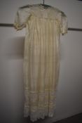 An antique gossamer fine silk childs gown, having lace to bodice and hem, hem interspersed with a
