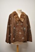 A vintage Art Deco beaded cape, having beige felt ground with blue, bronze and clear beads, fully