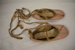 A pair of vintage child's pink leather ballet shoes.