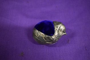 A silver tone metal pincushion in the form of a chick, having iridescent blue/cerise velvet to top.