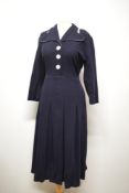 A navy blue wool day dress, having contrasting black and white edge to unusual shaped collar.