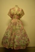 A late 1940s/early 1950s semi sheer day dress, having floral pattern, larger size.