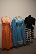 Three vintage dresses, including 1960s tangerine coloured satin maxi dress, blue satin dress and