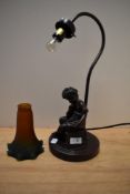 A 20th Century bronze effect figural table lamp with amber glass shade