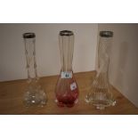 An Art Nouveau ruby coloured glass vase, and two other clear glass vases of similar design, all with
