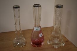 An Art Nouveau ruby coloured glass vase, and two other clear glass vases of similar design, all with