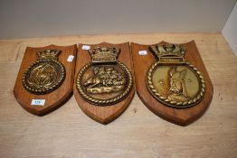Three stained oak armorial plaques, Agincourt, Tally Ho, and Warrior