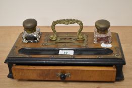 An Edwardian desk companion with brass handle, having two glass inkwells, pen tray and drawer.
