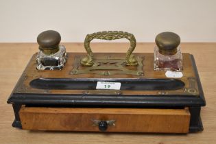 An Edwardian desk companion with brass handle, having two glass inkwells, pen tray and drawer.