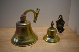 A cast brass ship's bell, 22cm tall, and another with relief moulded bracket