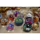 An assorted collection of art glass paperweights, by Caithness glass, and others