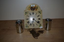 A vintage wooden chiming wall clock, having flowers and butterfly decoration to face.