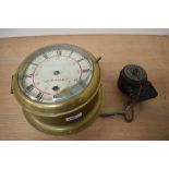 An antique brass ships Bolkhead clock, having bevelled glass door and roman numerals to face,'SS