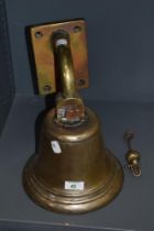 A vintage heavy brass wall mounted, with clapper.