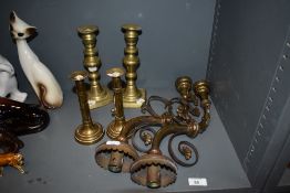 A pair of Victorian brass wall light fittings and two pairs of brass candlesticks