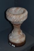 A 20th century variegated alabaster font.