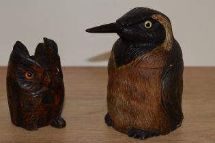 An early to mid 20th century treen pot in the form of a penguin, having glass eyes and a carved