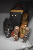 A selection of carved treen tribal art, including mask, plaque and two antique studies.