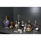 An assorted collection of art glass scent bottles, an atomizer of similar design, an A.E Williams