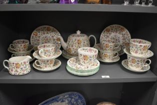 A selection of Minton 'Haddon Hall' plates, teapot, cups and saucers, milk and sugar.