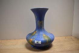 A mid century studio pottery vase, having blue ground with drip glaze in orange, yellow and green.