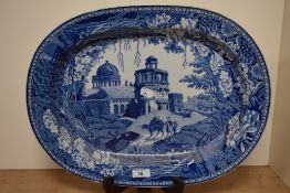 A large blue and white platter, having foliate border with traditional scene of buildings and people