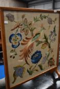 A traditional oak frame embroidered firescreen