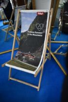 A traditional deckchair , having promotional canvas print for Tirol