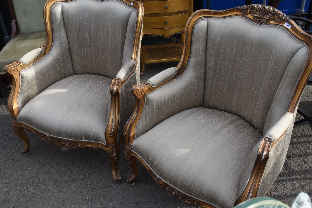 A pair of French gilt wood easy chairs