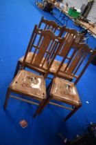 A set of four early 20th Century transitional golden oak dining chairs having later drop in seats