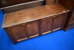 A traditional stained frame bedding chest , having lift lid and panelled doors to front