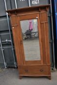 A late Victorian oak mirror door wardrobe