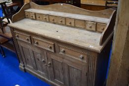 A traditional natural sideboard/low dresser with spice drawers to top ledge