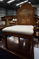 A reproduction carver chair having cane back and upholstered seat