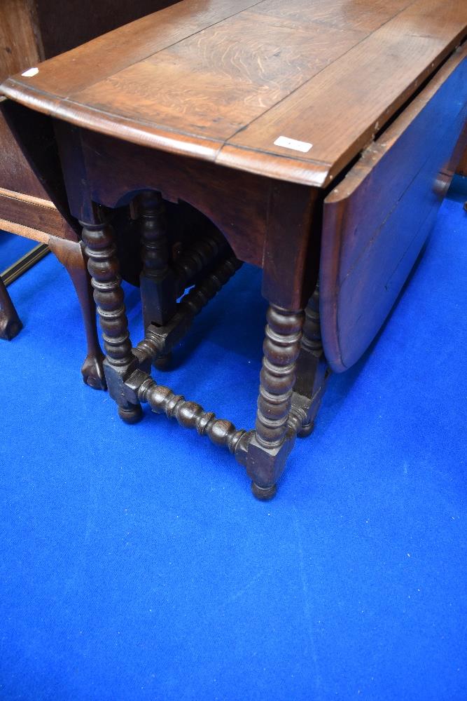 A period oak drop leaf dining table having turned gate legs