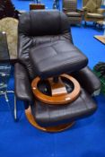 A vintage brown leather swivel chair and similar footstool, similar to stressless