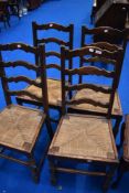 A set of four traditional ladderback kitchen chairs having strung seats