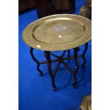 An Eastern style brass topped folding table